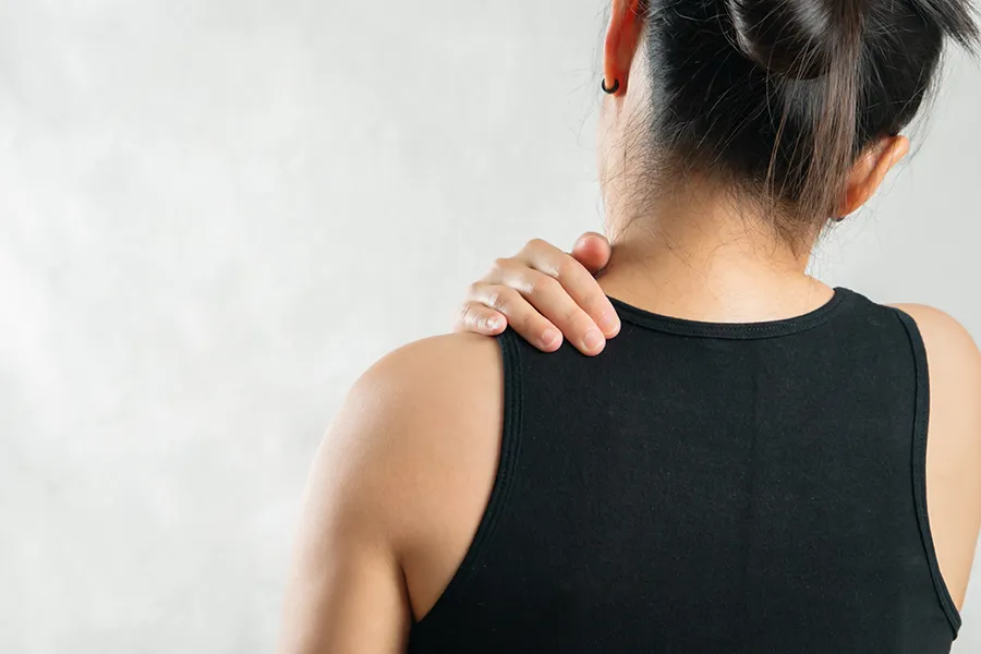 Person holding shoulder due to discomfort, representing conditions that may be treated with PRP therapy