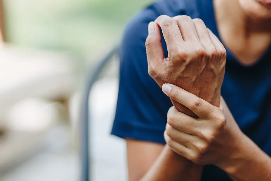 Person holding wrist in pain, representing tendon or ligament injury treated with PRP therapy